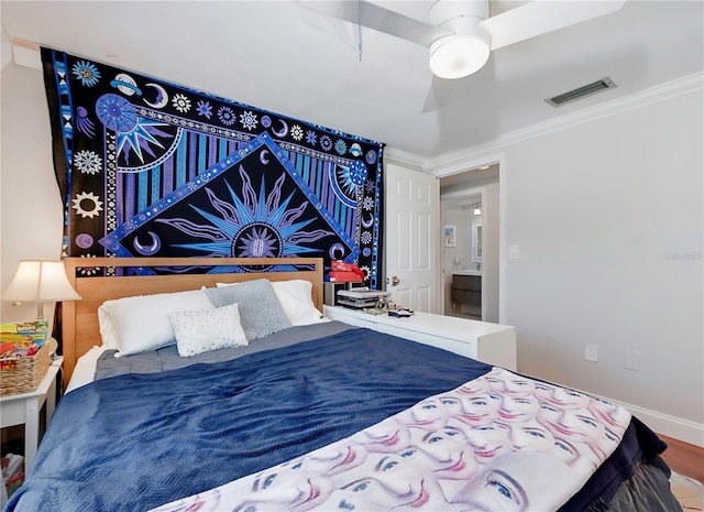 bedroom with a ceiling fan, baseboards, ornamental molding, visible vents, and wood finished floors