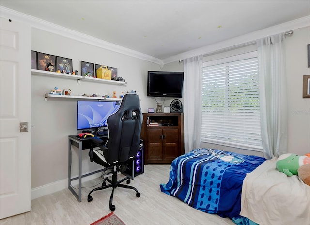 bedroom featuring baseboards, crown molding, and wood finished floors