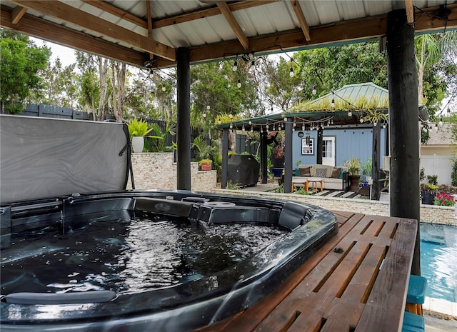 view of pool with hot tub deck surround, fence, a deck, and a gazebo