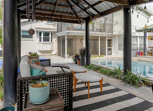 view of patio featuring a gazebo, an outdoor pool, and a balcony