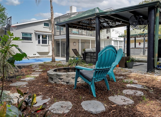 view of patio / terrace with a fire pit and a balcony