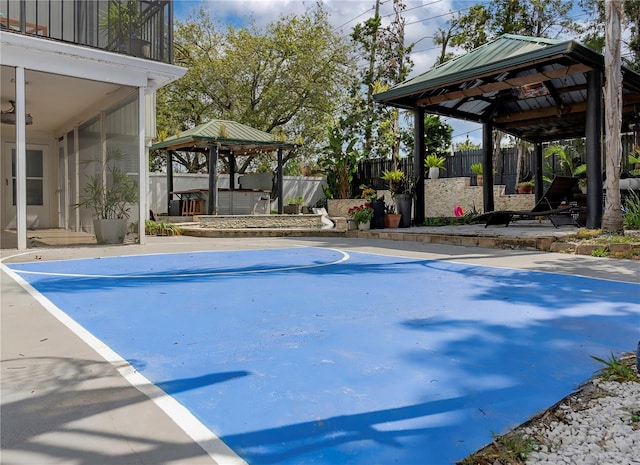 view of sport court featuring fence and a gazebo