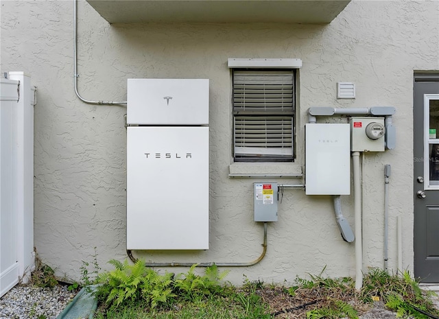 exterior details featuring stucco siding and electric meter