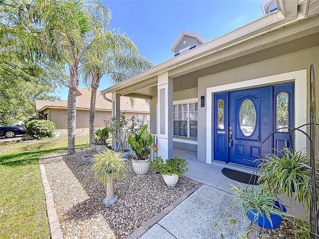 entrance to property with stucco siding and a porch