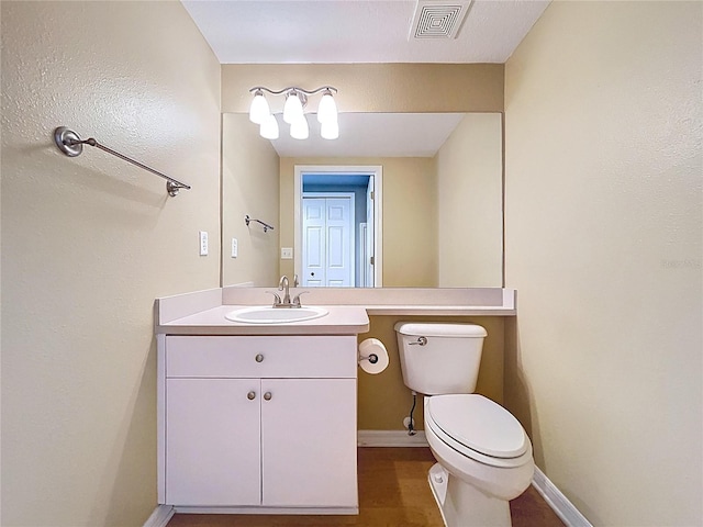 bathroom with visible vents, toilet, vanity, and baseboards