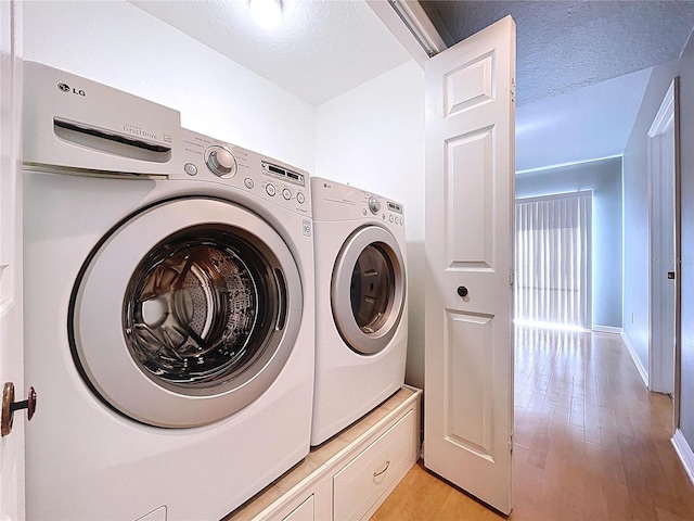 laundry area featuring light wood-style floors, laundry area, and independent washer and dryer