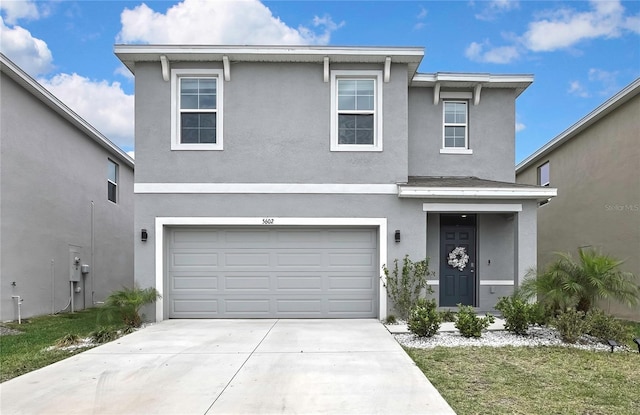 traditional home with concrete driveway, stucco siding, and an attached garage