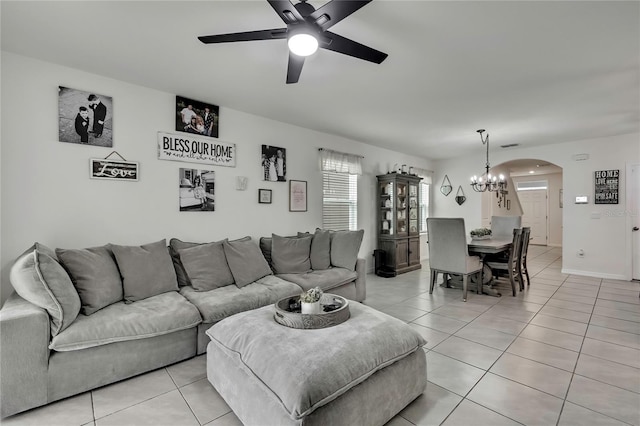 living room with visible vents, arched walkways, light tile patterned flooring, and ceiling fan with notable chandelier
