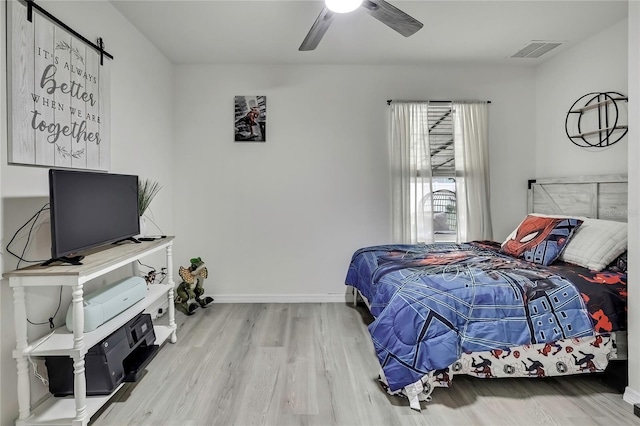 bedroom with visible vents, baseboards, a ceiling fan, and wood finished floors