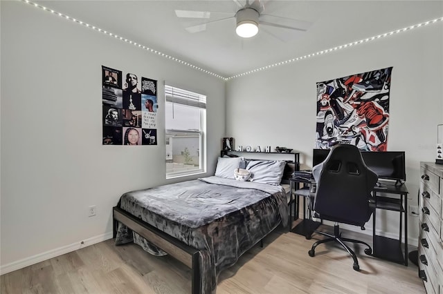 bedroom featuring wood finished floors, baseboards, and a ceiling fan