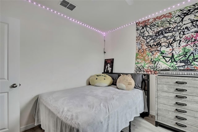 bedroom with visible vents and wood finished floors