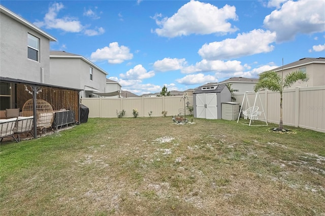view of yard with a storage unit, a fenced backyard, a residential view, and an outdoor structure