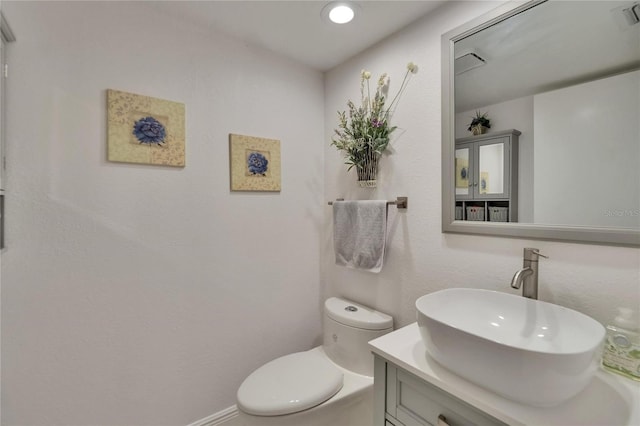 bathroom featuring vanity, visible vents, and toilet