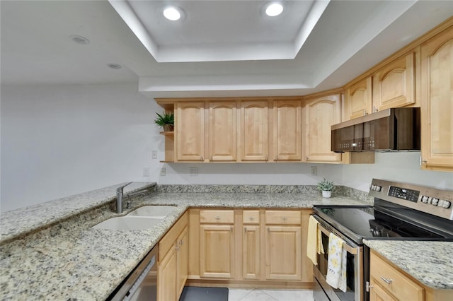 kitchen with light stone countertops, appliances with stainless steel finishes, a sink, a raised ceiling, and light brown cabinets