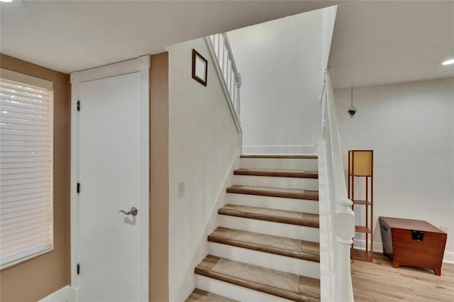 stairway with baseboards and wood finished floors