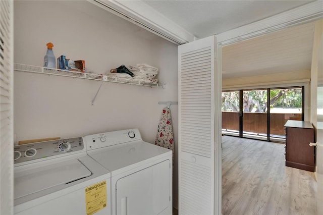 clothes washing area with laundry area, light wood-style floors, and washer and clothes dryer