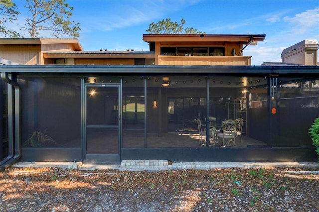 rear view of property featuring a sunroom