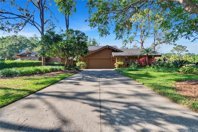 view of front of property with a garage, a front yard, driveway, and stucco siding