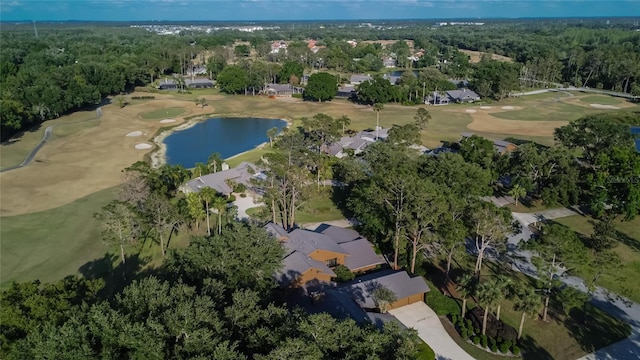 birds eye view of property featuring a forest view, view of golf course, and a water view