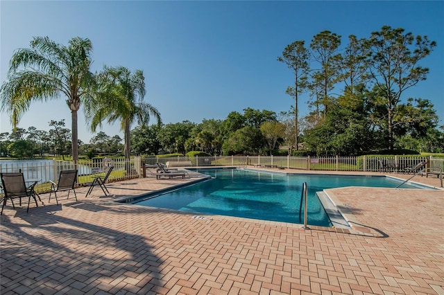 pool with a patio area and fence