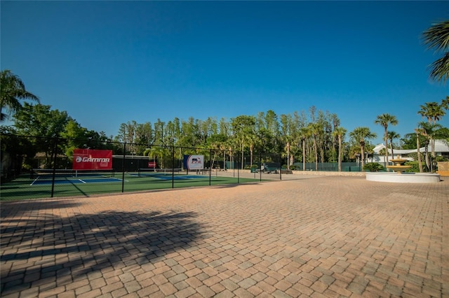 surrounding community featuring a tennis court and fence