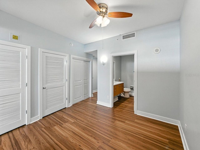 1208 E Kennedy Blvd Unit 1125, Tampa, FL 33602 - unfurnished bedroom with wood finished floors, two closets, ensuite bath, and a ceiling fan