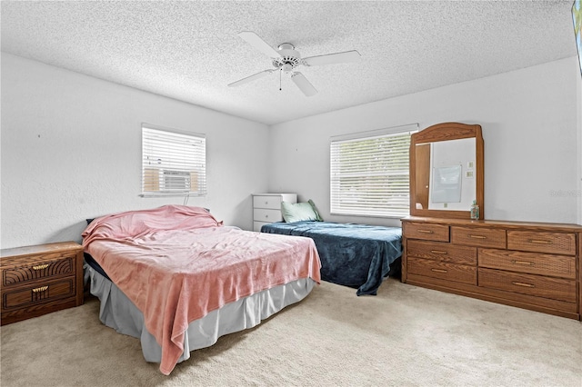 bedroom featuring a textured ceiling, multiple windows, and light carpet
