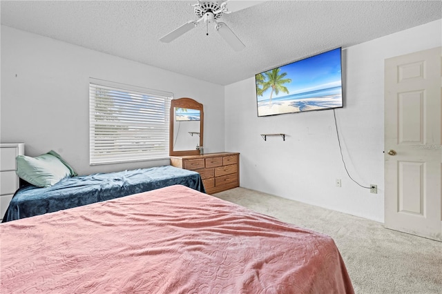 bedroom with ceiling fan, light carpet, and a textured ceiling