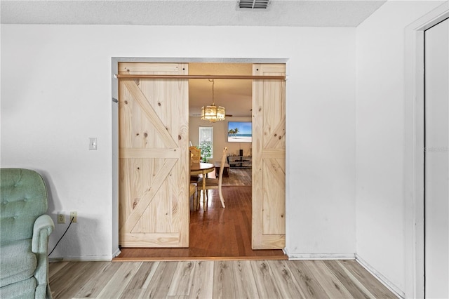 living area with visible vents, baseboards, and wood finished floors