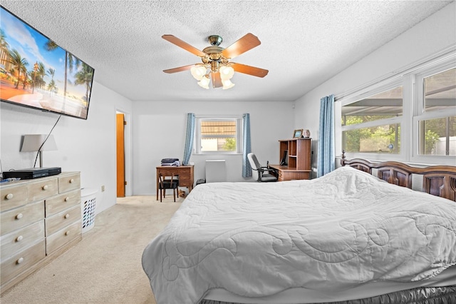 bedroom with carpet floors, a ceiling fan, and a textured ceiling