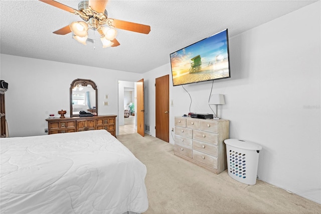 carpeted bedroom featuring a textured ceiling and ceiling fan