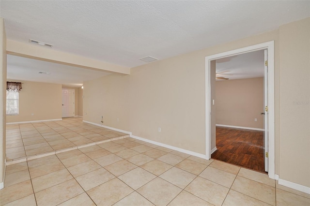 spare room featuring light tile patterned floors, baseboards, and visible vents