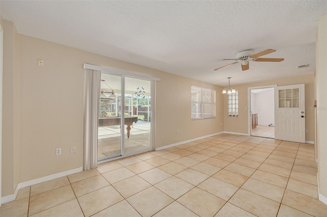 unfurnished room featuring ceiling fan with notable chandelier, a textured ceiling, visible vents, light tile patterned flooring, and baseboards