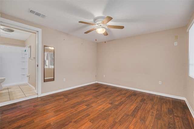 spare room with visible vents, baseboards, a ceiling fan, and wood finished floors