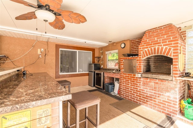interior space with a sink, ceiling fan, beverage cooler, and area for grilling