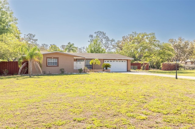 ranch-style house with concrete driveway, stucco siding, fence, and a front lawn