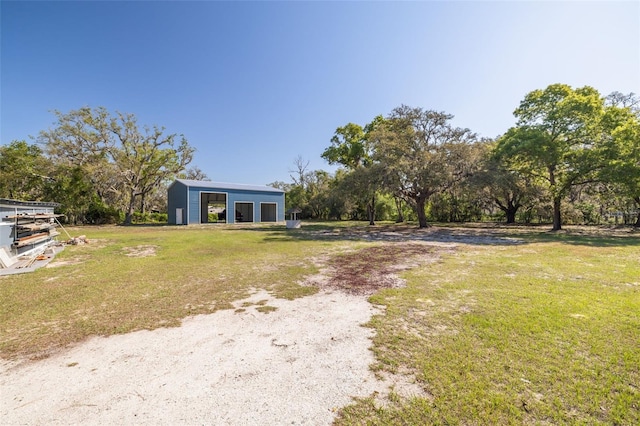 view of front of house featuring a front yard, a pole building, an outdoor structure, and a garage