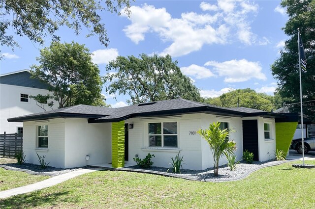 7101 N 9th St, Tampa, FL 33604 - view of front of home with a front lawn, stucco siding, and a shingled roof