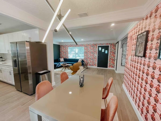 7101 N 9th St, Tampa, FL 33604 - dining room featuring wallpapered walls, light wood-style flooring, crown molding, and baseboards