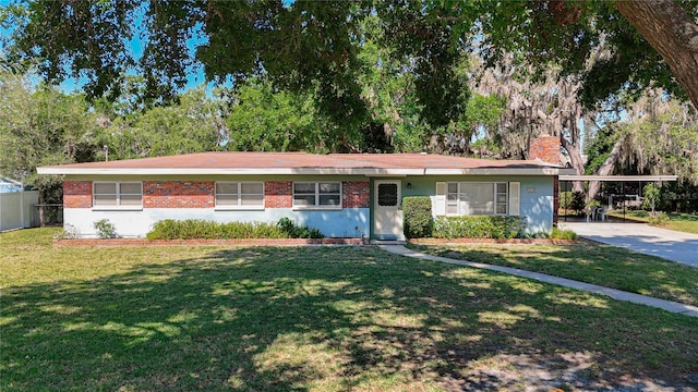13116 N Oregon Ave, Tampa, FL 33612 - ranch-style home featuring a front lawn, a carport, driveway, a chimney, and fence