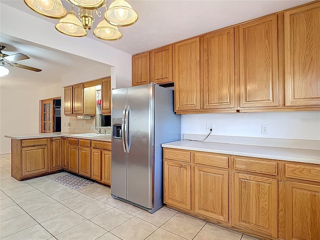 13116 N Oregon Ave, Tampa, FL 33612 - kitchen with a peninsula, a sink, brown cabinetry, stainless steel refrigerator with ice dispenser, and light countertops