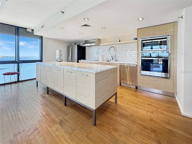 kitchen with modern cabinets, stainless steel appliances, and light wood-type flooring