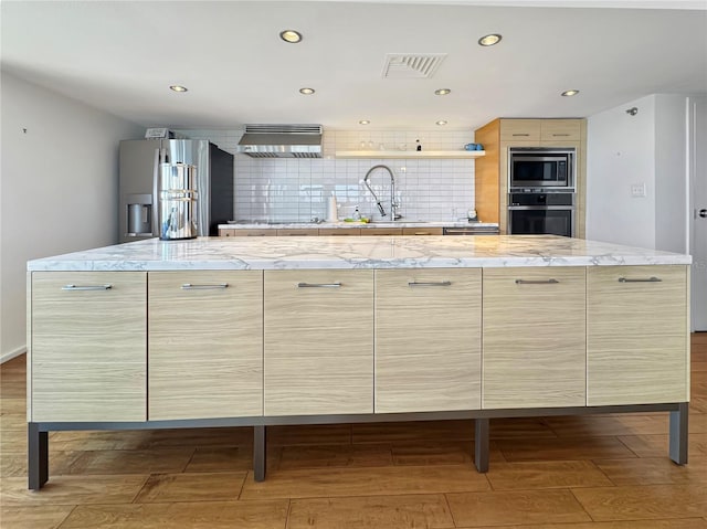 kitchen featuring modern cabinets, appliances with stainless steel finishes, and visible vents