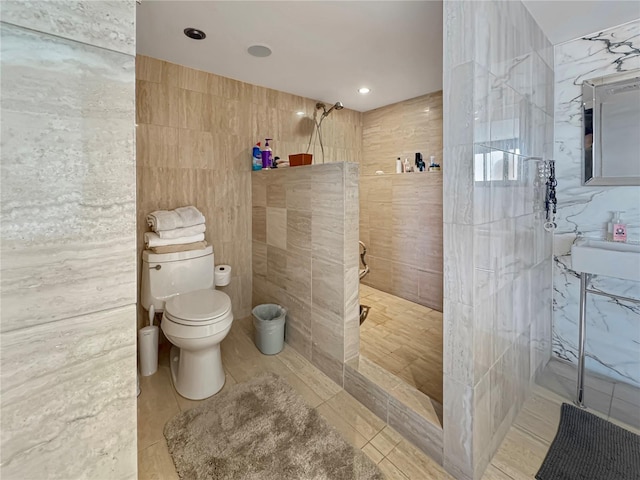 bathroom with toilet, tile patterned flooring, a walk in shower, and tile walls