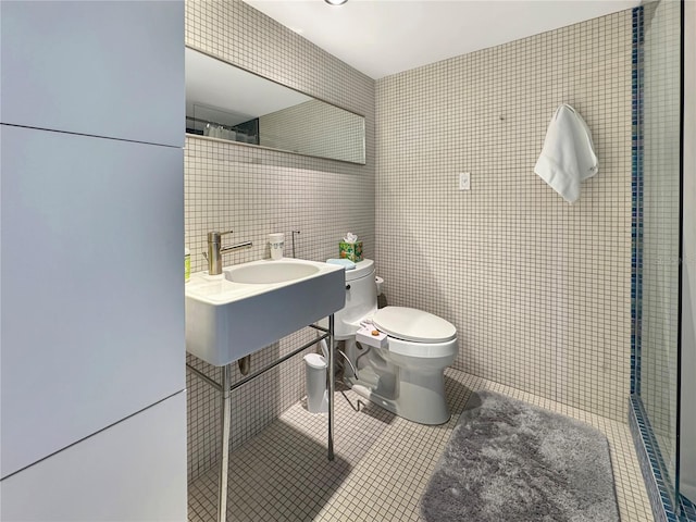 bathroom featuring tile patterned flooring, tile walls, toilet, and tiled shower