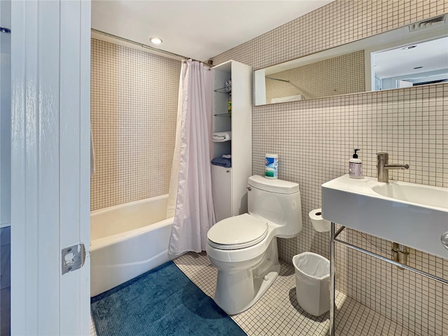 full bathroom featuring tile patterned floors, visible vents, toilet, tile walls, and shower / tub combo with curtain