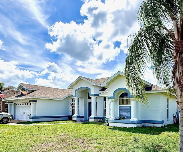 ranch-style home featuring stucco siding, a front yard, an attached garage, and a shingled roof