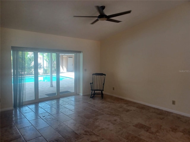 unfurnished room featuring a ceiling fan, baseboards, and vaulted ceiling