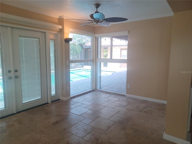 empty room featuring baseboards, stone tile flooring, and ceiling fan