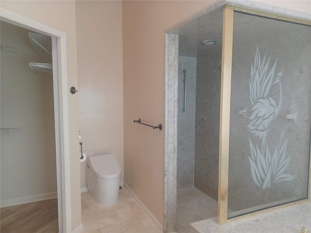 full bath featuring baseboards, a walk in shower, and toilet